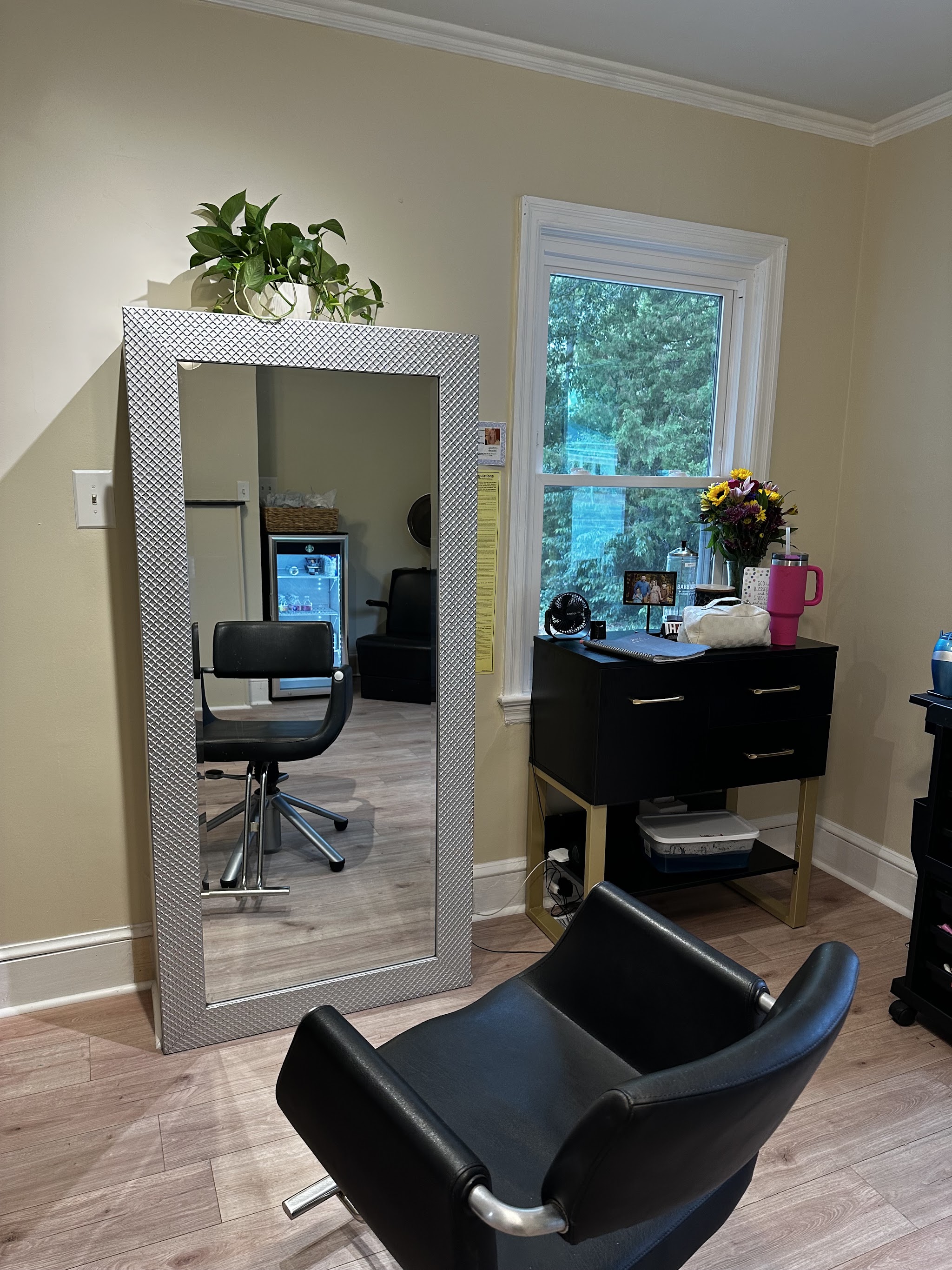 A styling chair in front of a full-length mirror and a window in the studio
